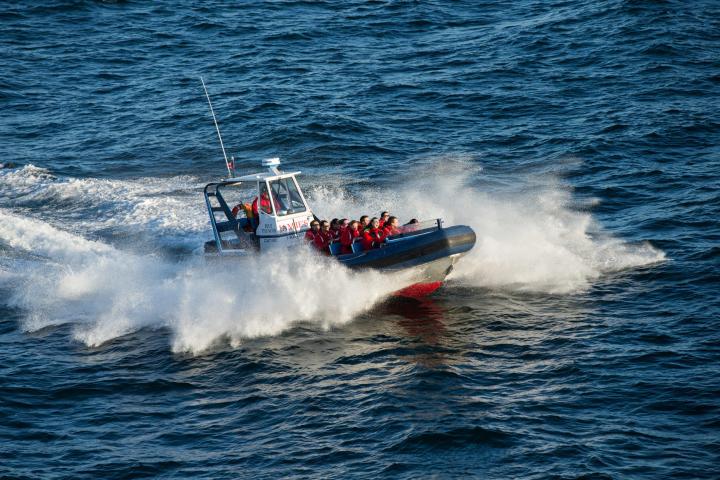 a man riding on the back of a boat in a body of water