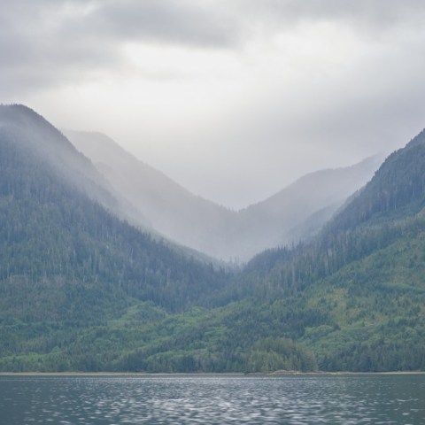 a large body of water with a mountain in the background