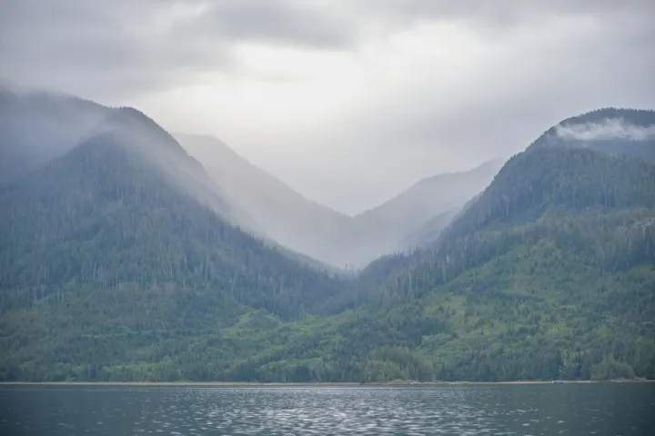 a large body of water with a mountain in the background
