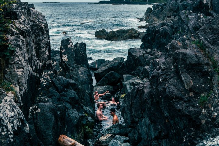 group of people in the natural rock thermal pools at hot springs cove