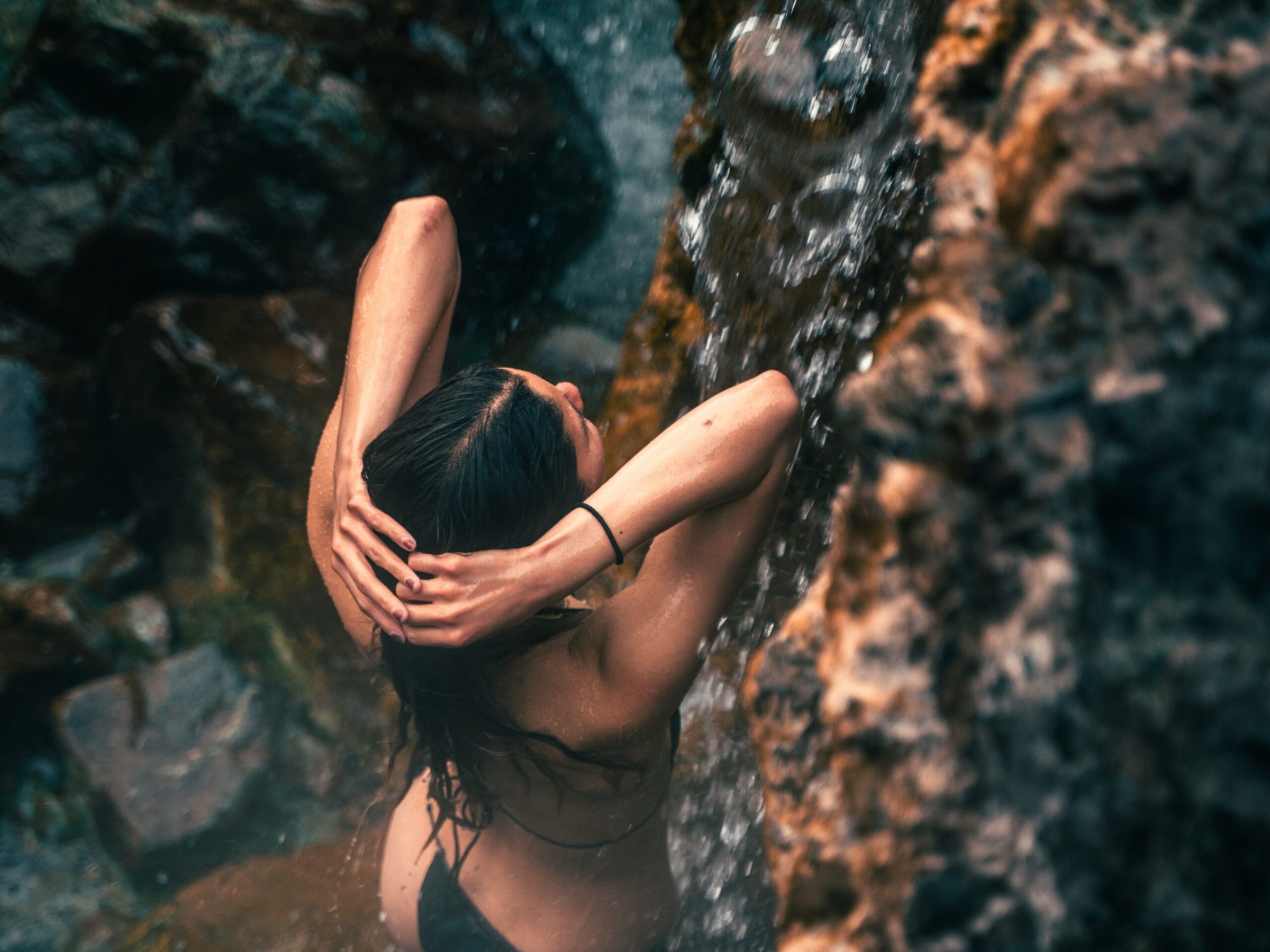 a woman enjoying the natural thermal waterfall and pools at hot springs cove