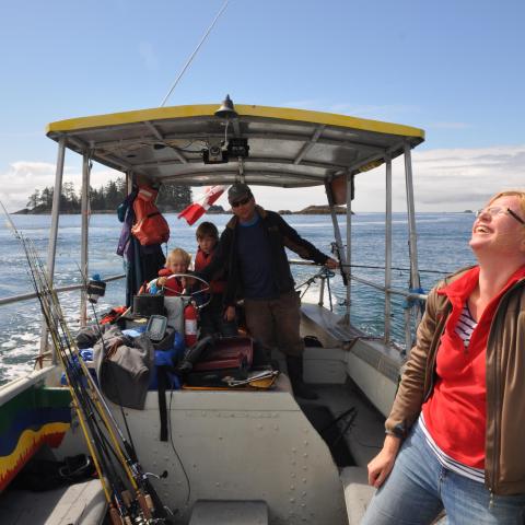 a man standing in front of a boat next to a body of water