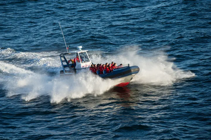 a man riding on the back of a boat in a body of water