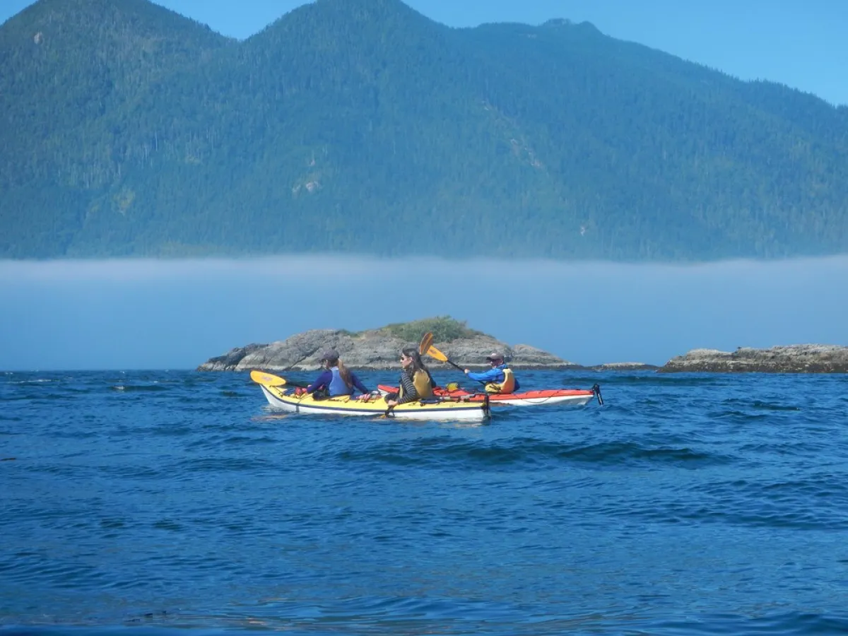 a small boat in a body of water with a mountain in the background