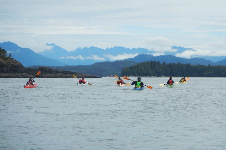 a group of people in a small boat in a body of water